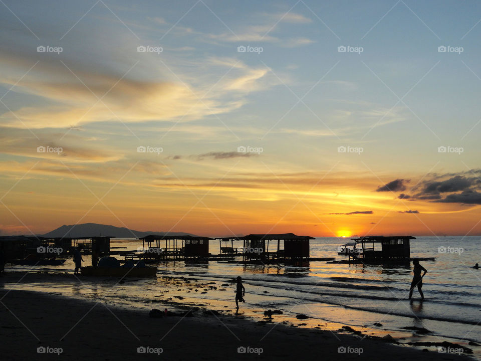 Scenic view of beach against sky at sunset 