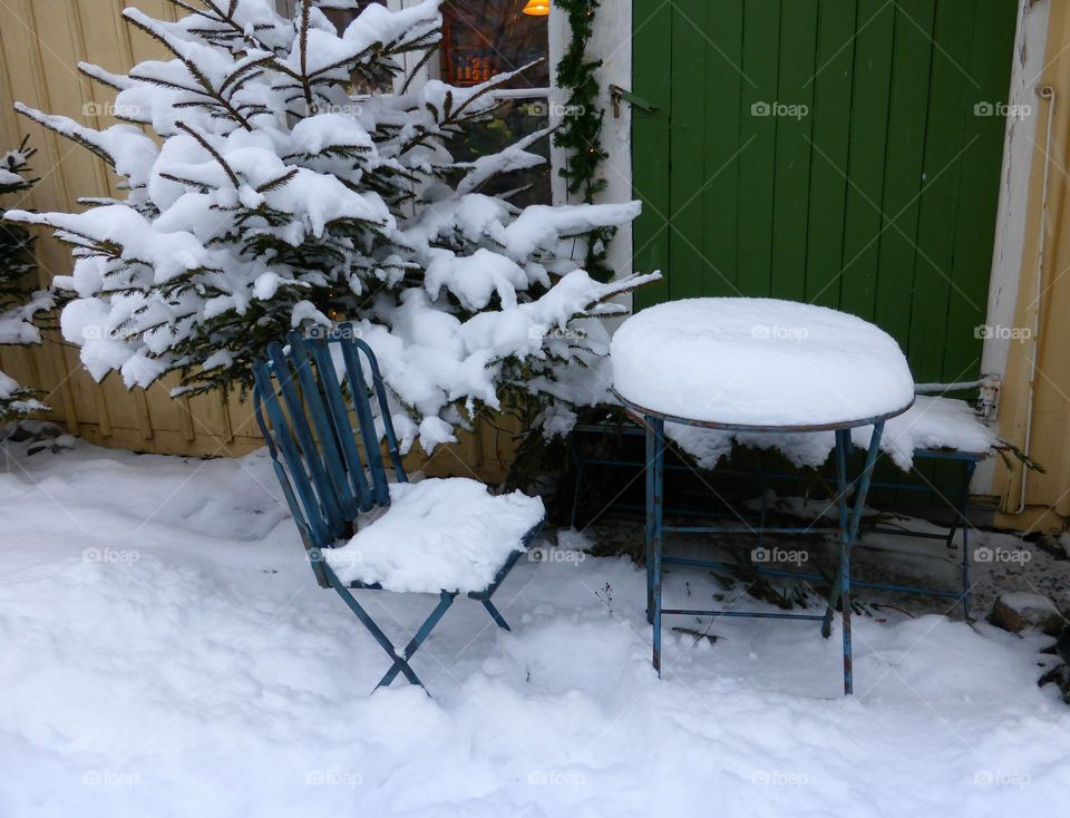 Garden furniture covered with snow