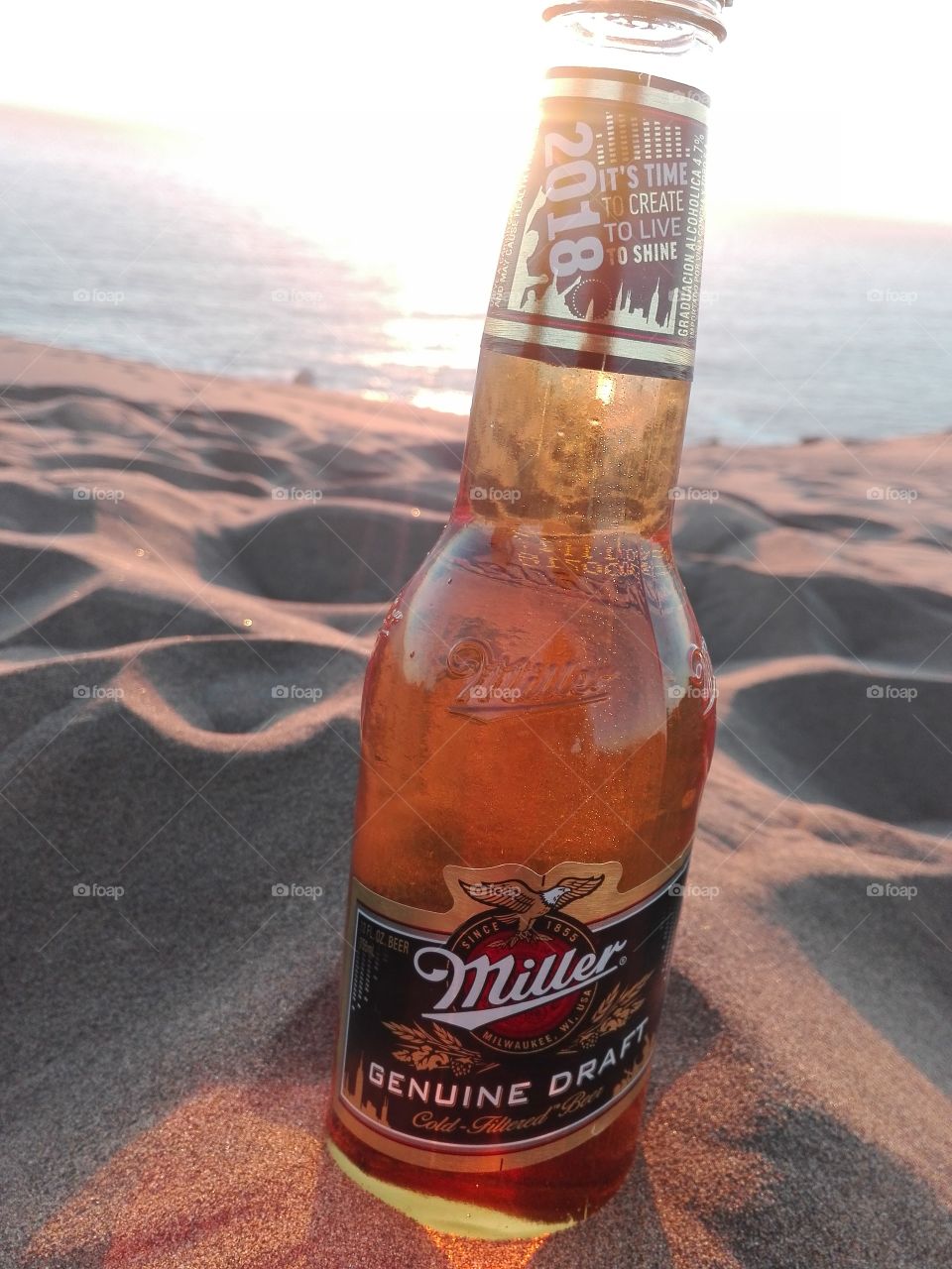 una botella de cerveza miller en la arena en las dunas de concon