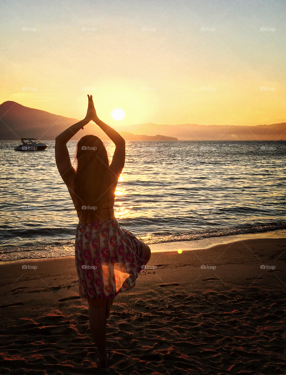 Yoga time . My girlfriend stares at the sun in a beautiful sunset in Ilhabela island in Brazil. 