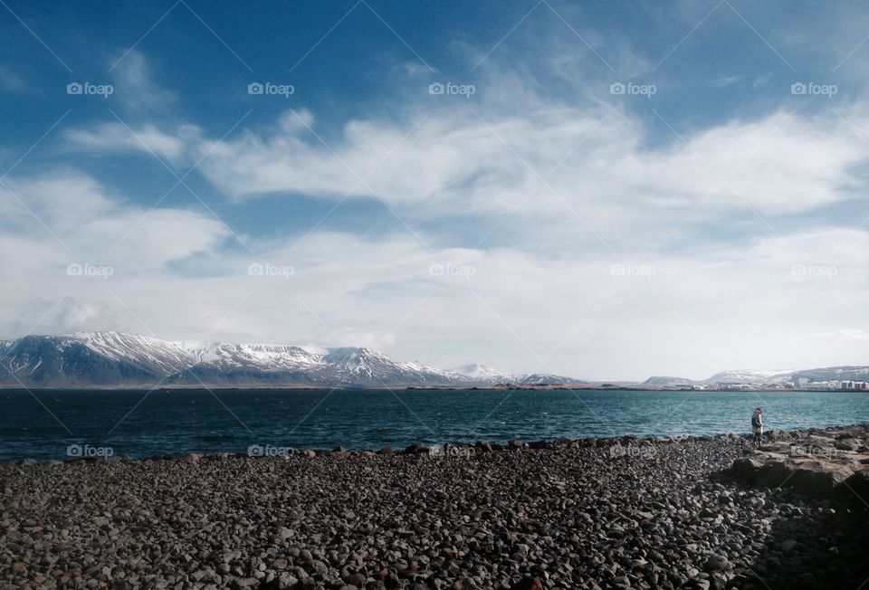 Person walking on the shore in Reykjavik Iceland