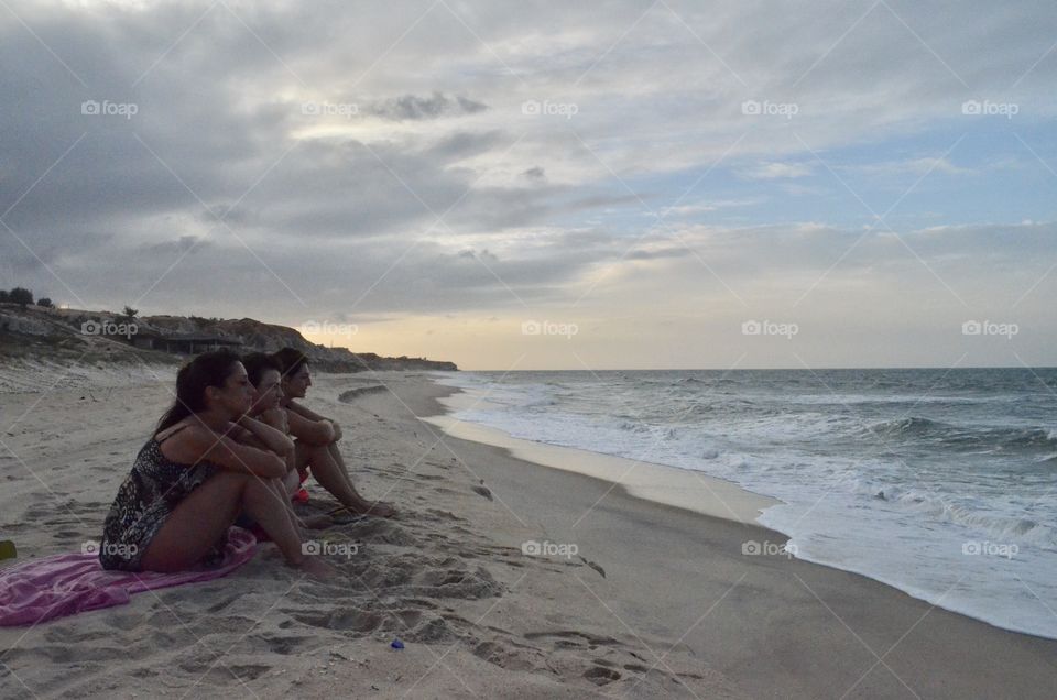 Three girls looking to the sea
