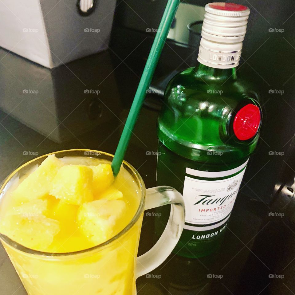 Tanquray Gin, mango pineapple juice and sode with lots of ice and frozen pineapple and mango topping 