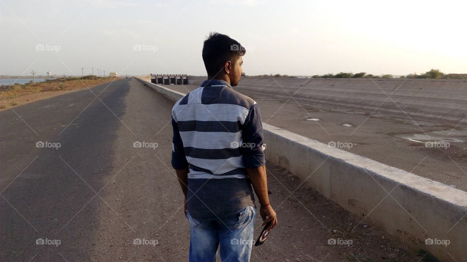 alone guy standing on road