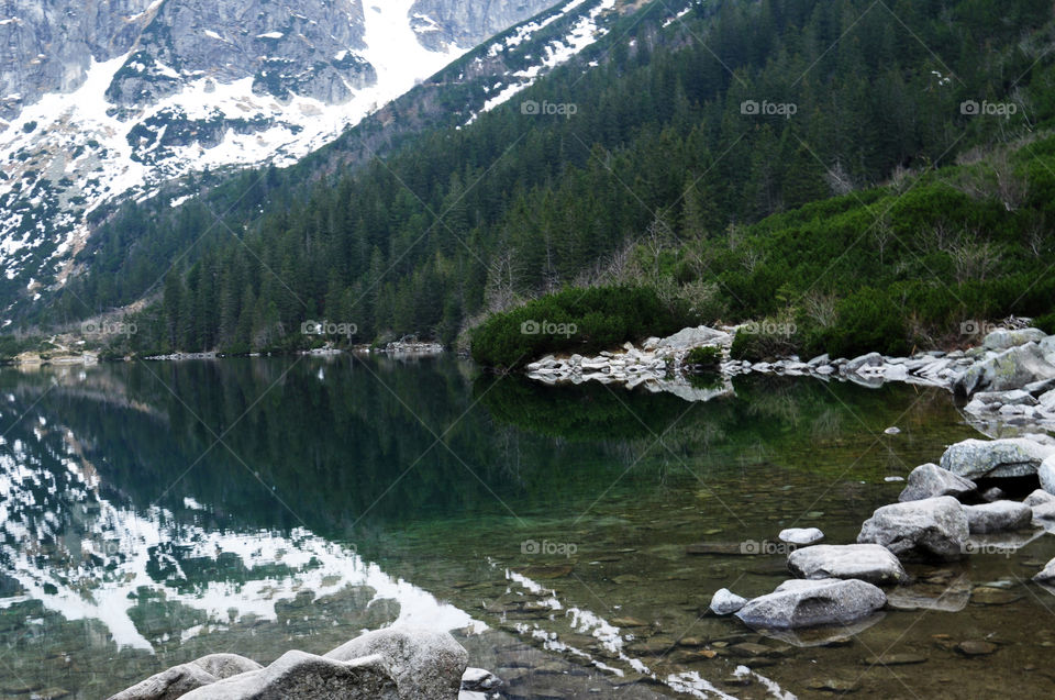 Snowy mountains reflected on lake