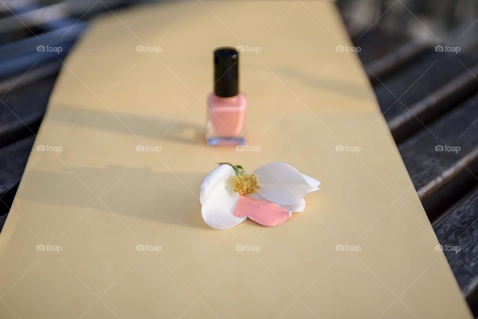 Pink nail polish on yellow background