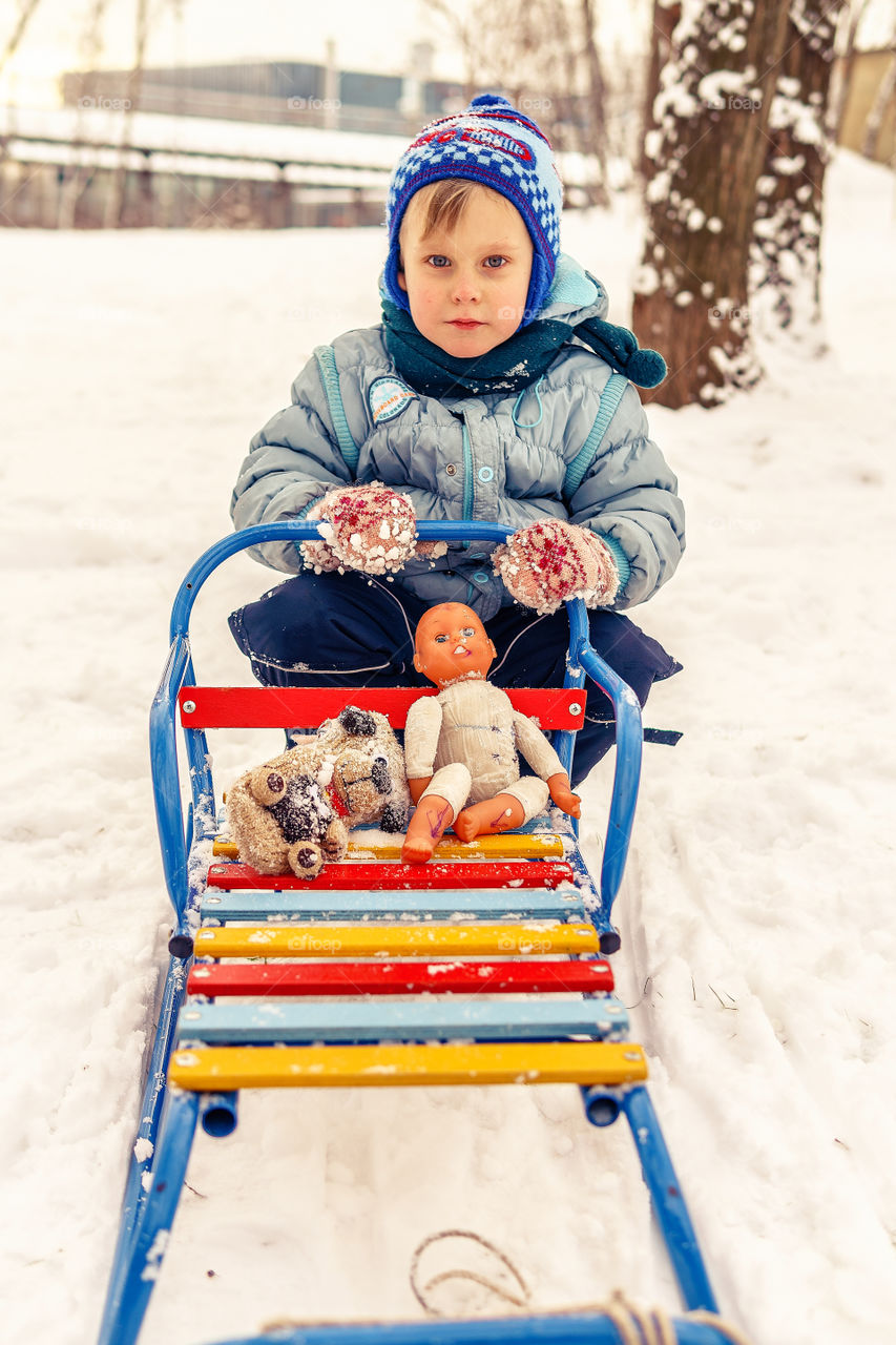 Little boy is playing with his toys outside