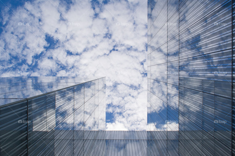 modern building reflecting the clouds in the sky 