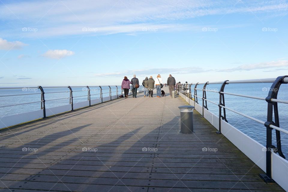 Family strolling on Saltburn pier with their dog 