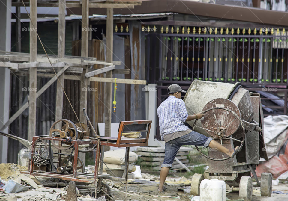 The workers are mixing cement in a cement mill.