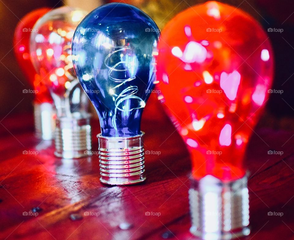 Four solar powered colorful light bulbs on a wooden pallet 