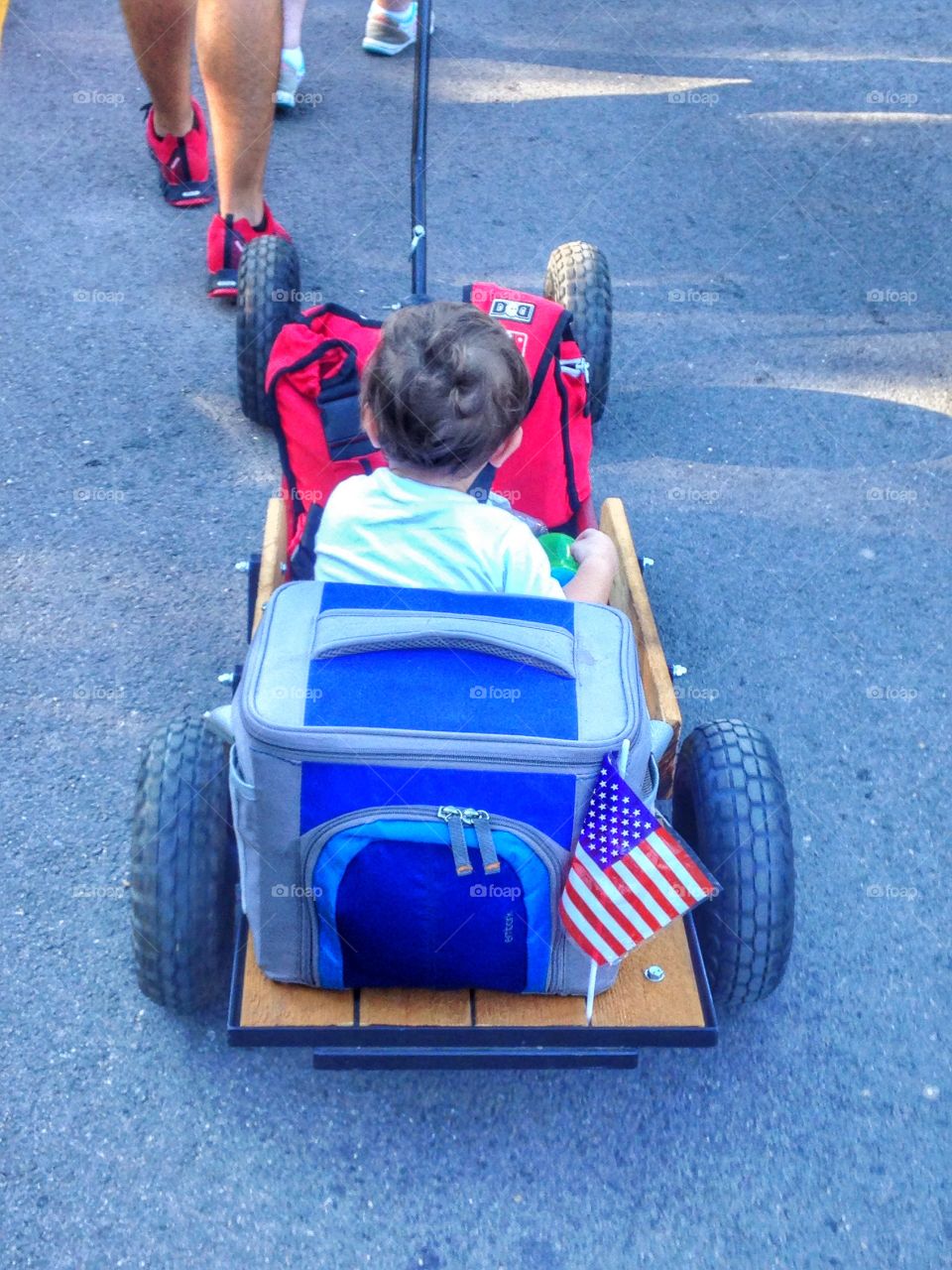 Just chillin'. Little boy riding in a wagon at a car show