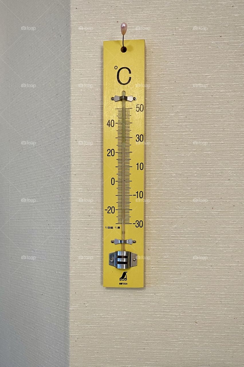 Yellow thermometer on the wall