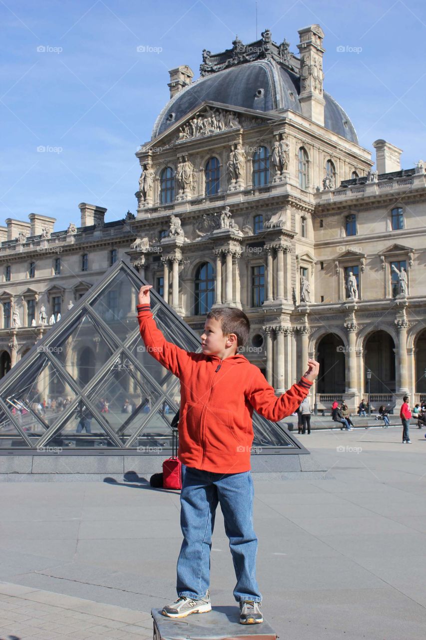 Kids/ boys in international travel playing at Louvre Museum in Paris France. Outdoor activities.