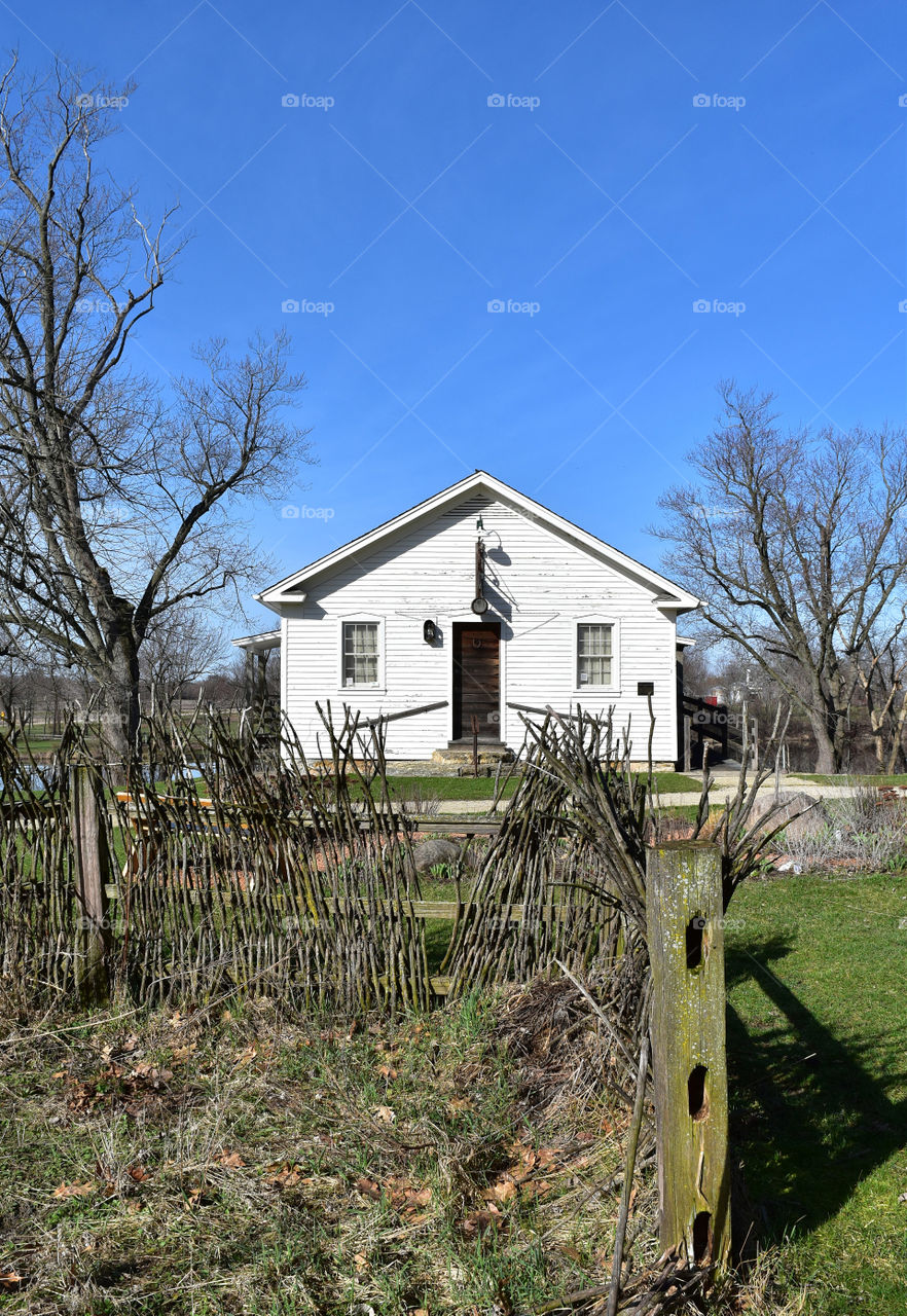 White farm building with a rustic fence