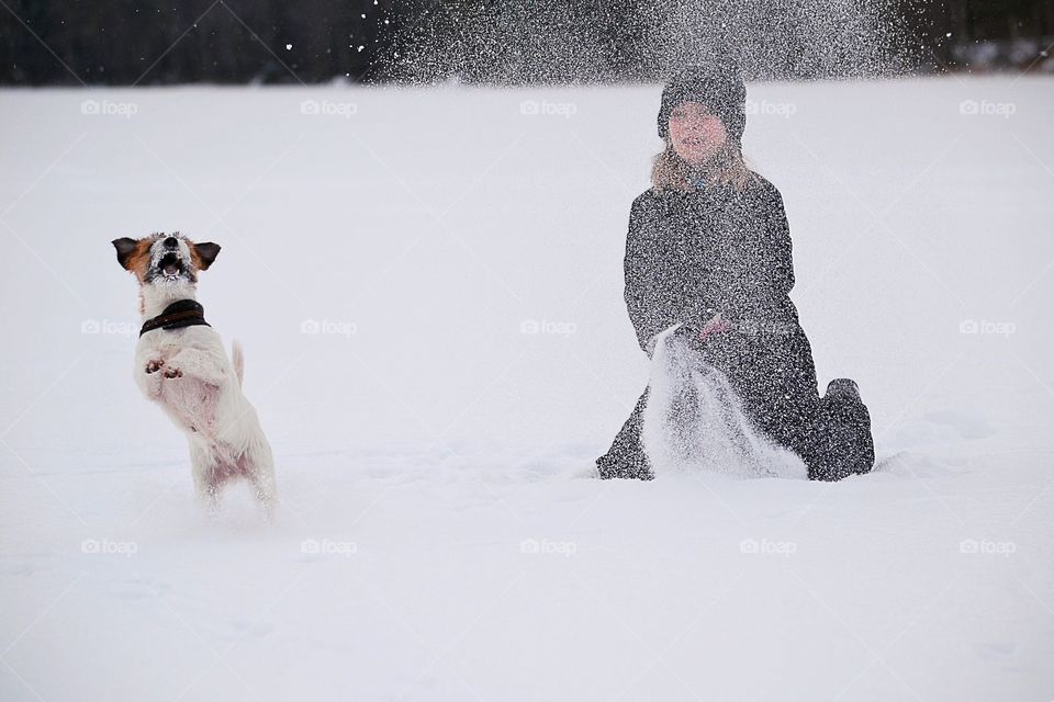 Girl playing with dog in snow