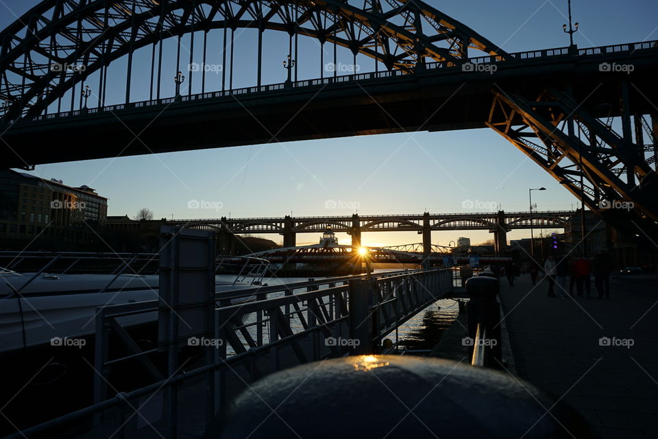 Photo taken of the Sun setting behind city bridges ... love how the sun is reflected on top of a piling ... natural light mission 