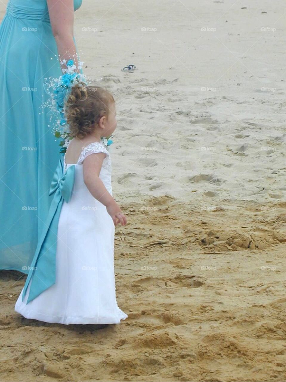 Beautiful little flower girl in the sand!
