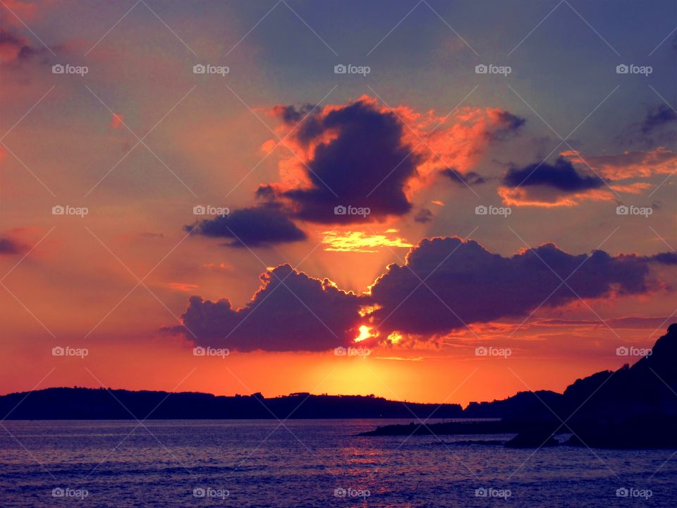 Water under the Sky on fire of Bacoli ( Naples - Italy ).