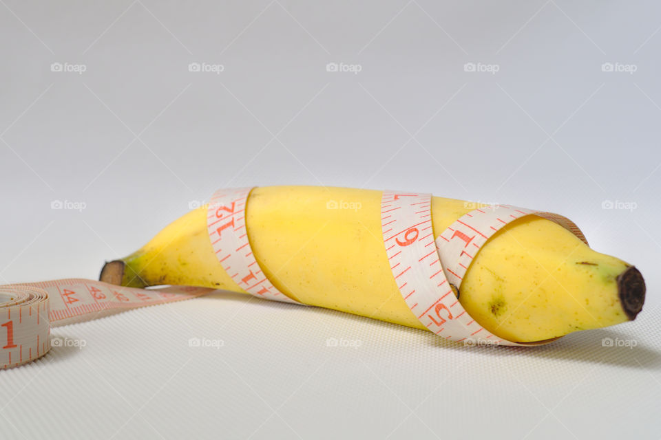 Penis size concept using banana, soft measuring tape