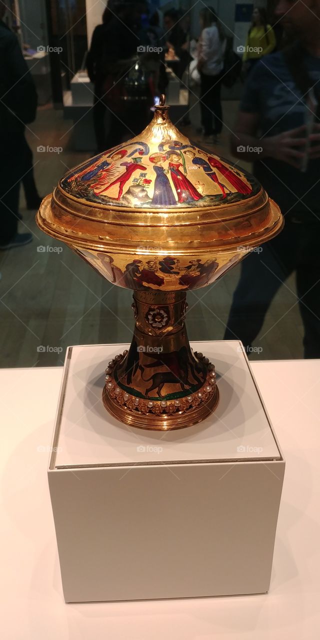 Museum exhibit of gold medieval cup in glass case