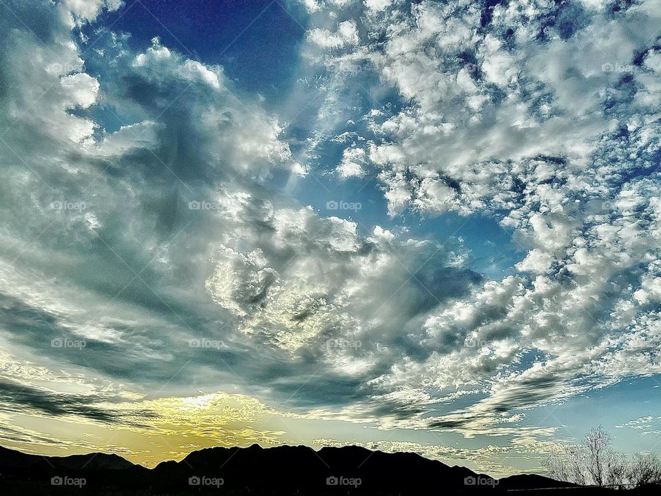 A photo of a cloudy sky with mountains below. 