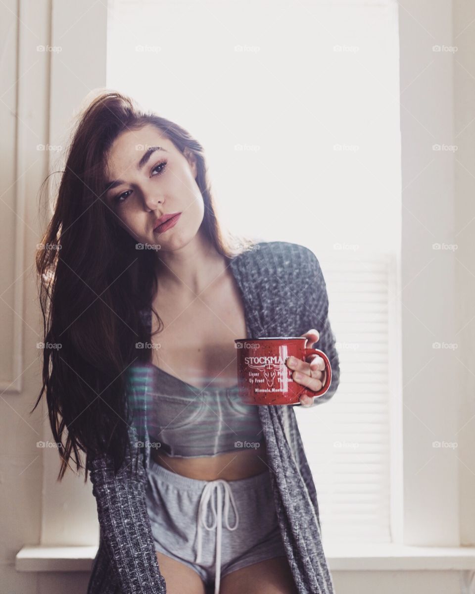 Brunette girl enjoying her morning tea in the kitchen. 