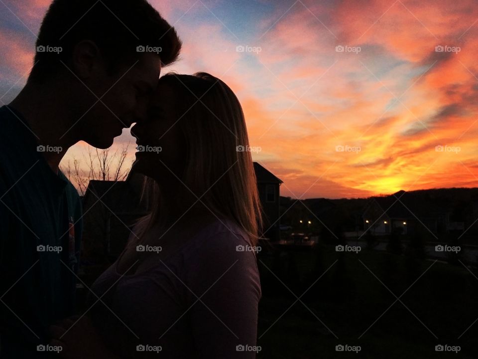 Couple enjoys a stolen romantic moment during a beautiful sunset