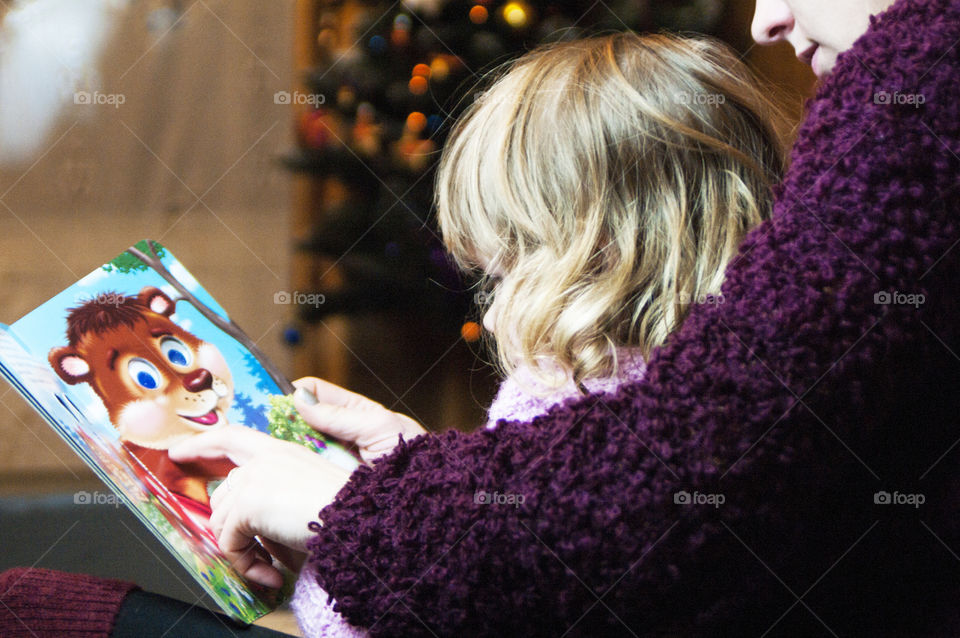 Mother little daughter reading book