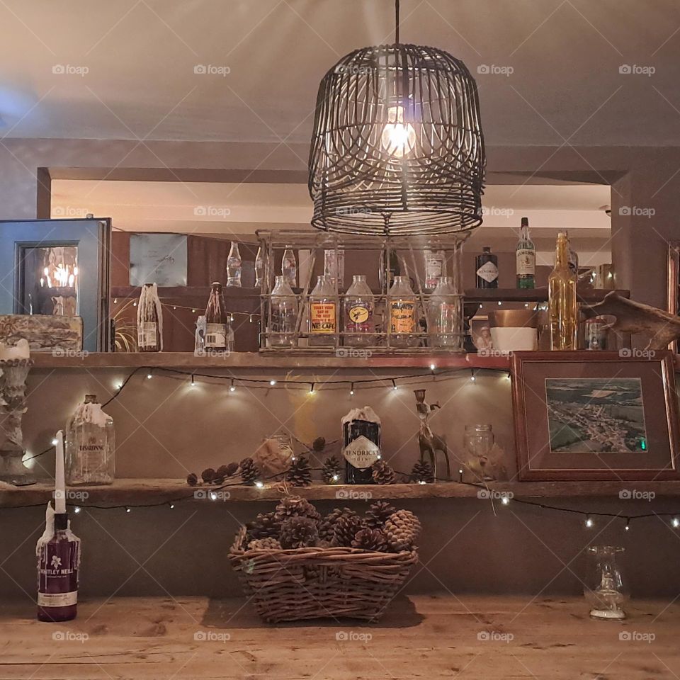 pub u.k. shelves with ornaments, cosy atmosphere. light. rustic. bottles, cones