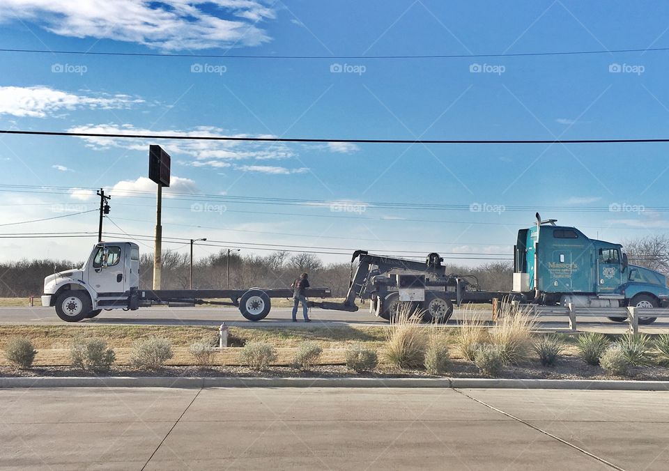 Big rig wrecker hauling a broke down oversized truck. 