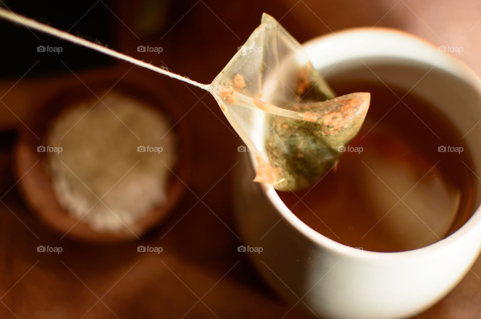 A cup with green tea with a teabag