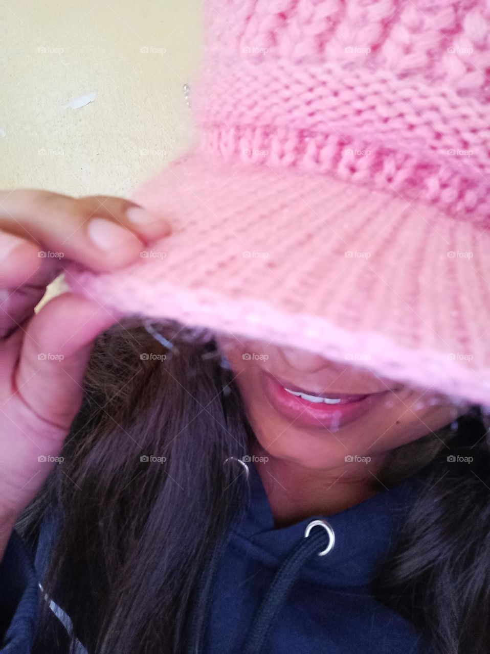 smiling girl and hiding her face through hat