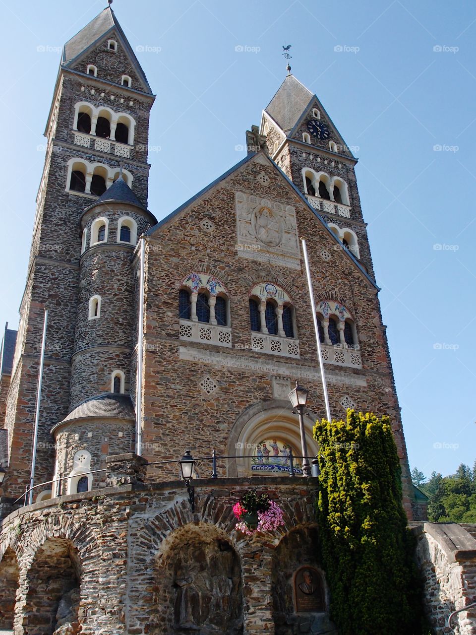 A beautiful old brick and stone monastery on a hill in Clervoux, Luxembourg on a sunny summer day. 