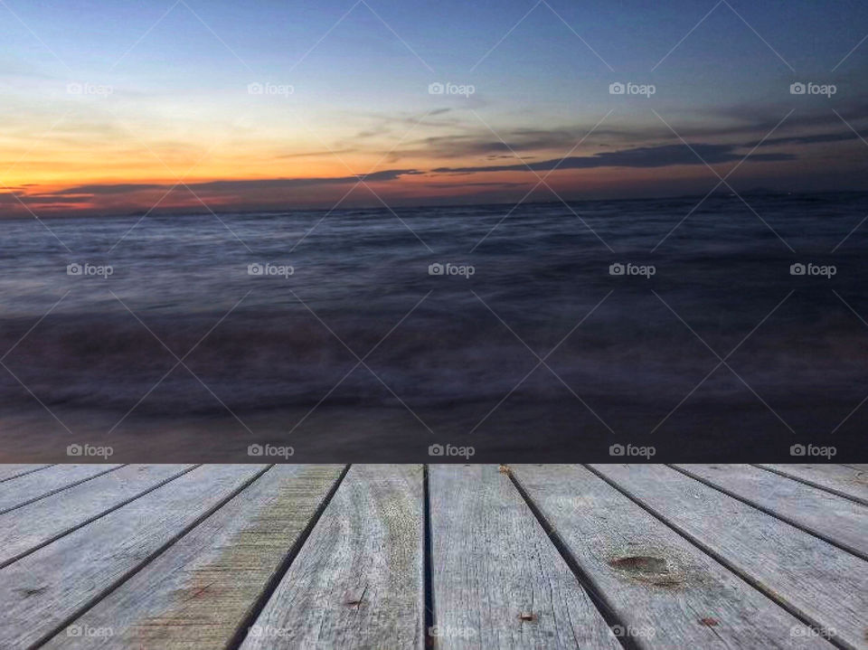 Empty top of wooden table and view of sunset tropical beach for product display. 