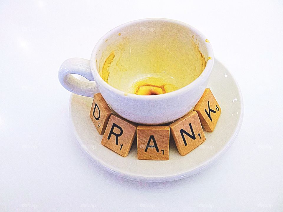 Empty coffee cup with scrabble tiles