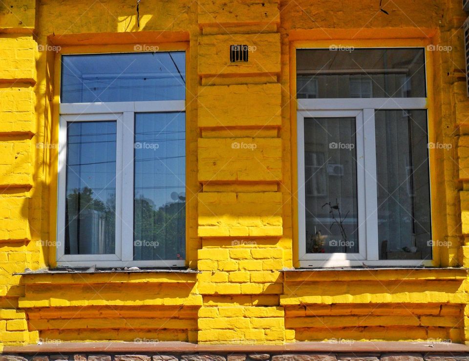 two windows of a yellow building