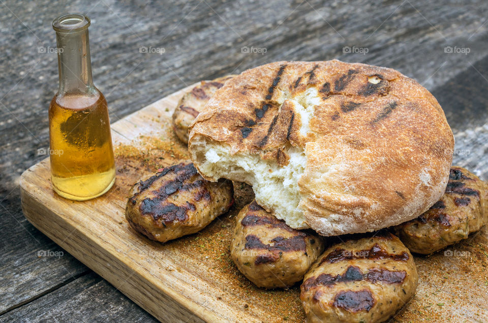 Delicious bread, fried meatballs and schnapps rakiq in a glass bottle with a narrow neck known as Yuzche