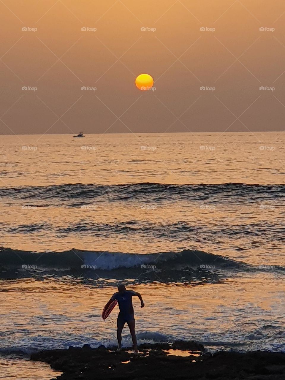 sunset at the beach with surfer