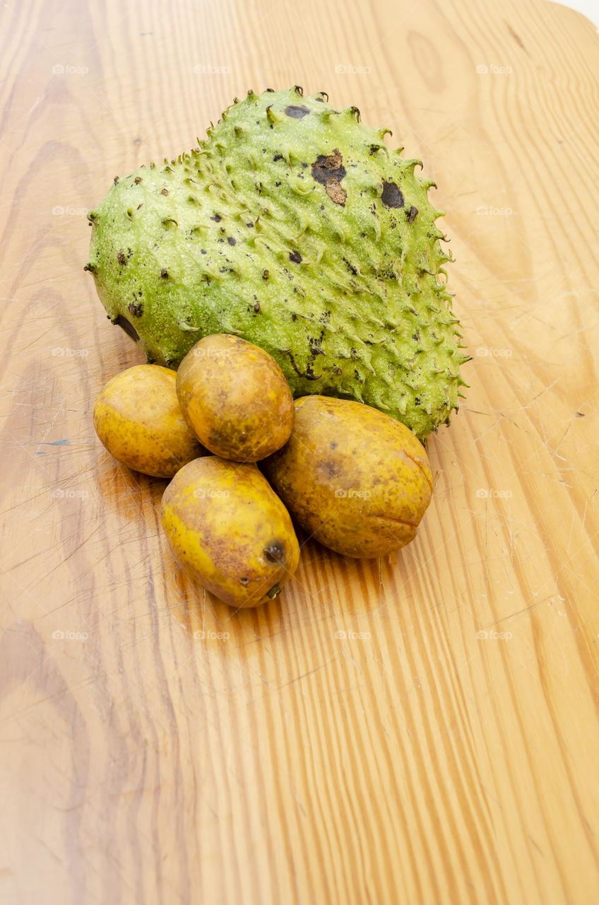 Soursop And June Plum On Board Surface