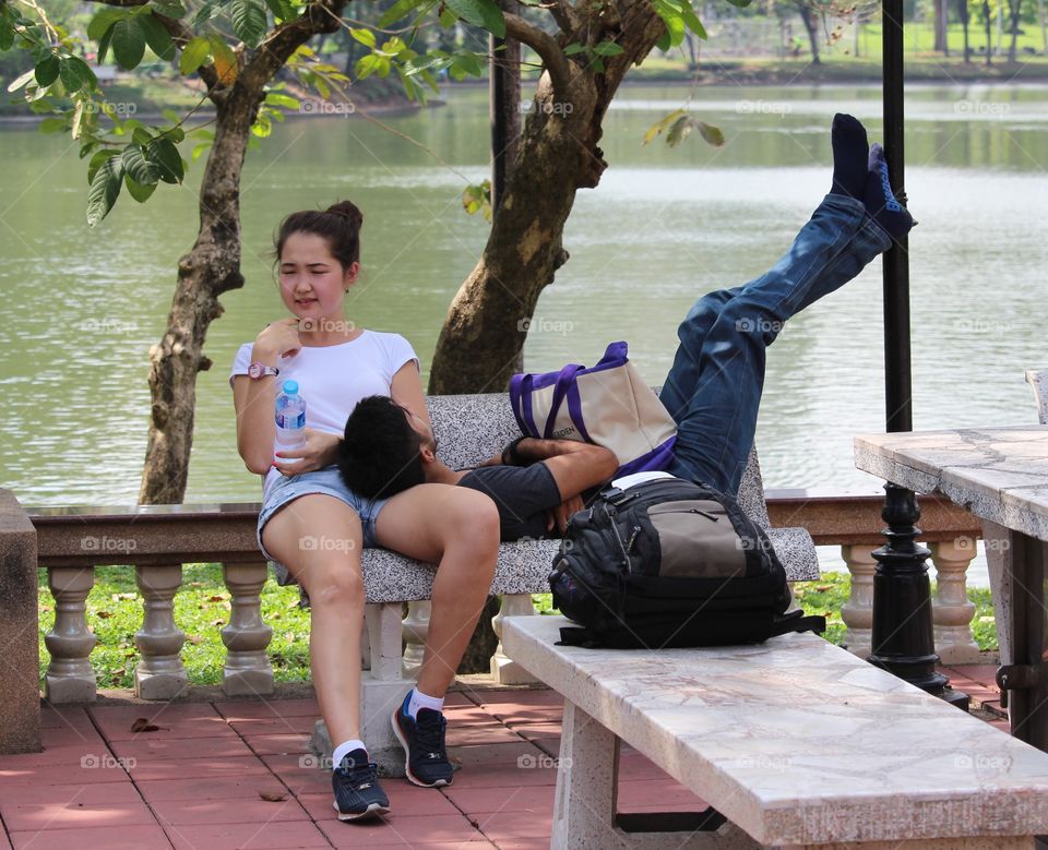 Relaxing couple at Lumpini Park Bangkok - January 2016