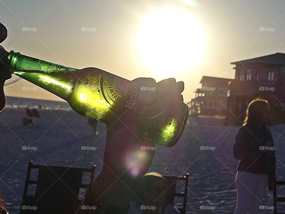 On a white sandy beach off the Gulf of Mexico in the glowing sunset drinking ice cold Heineken 