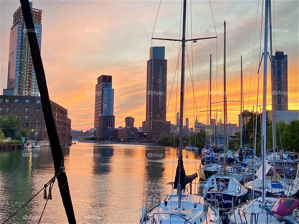 Another fiery evening time impression of the “East River” at “Newtown Creek” by the “Pulaski Bridge” in LIC, Queens, NY. The silhouettes of buildings from LIC as well as Manhattan in the far distance can be seen. 2022. Hypnotic Productions