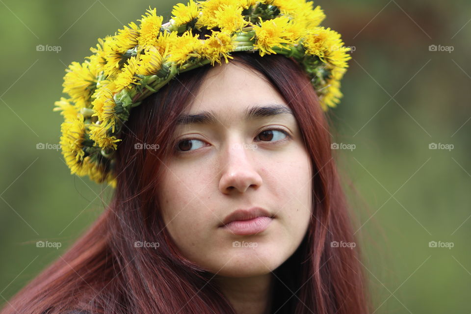 Beautiful girl in dandelions wreath