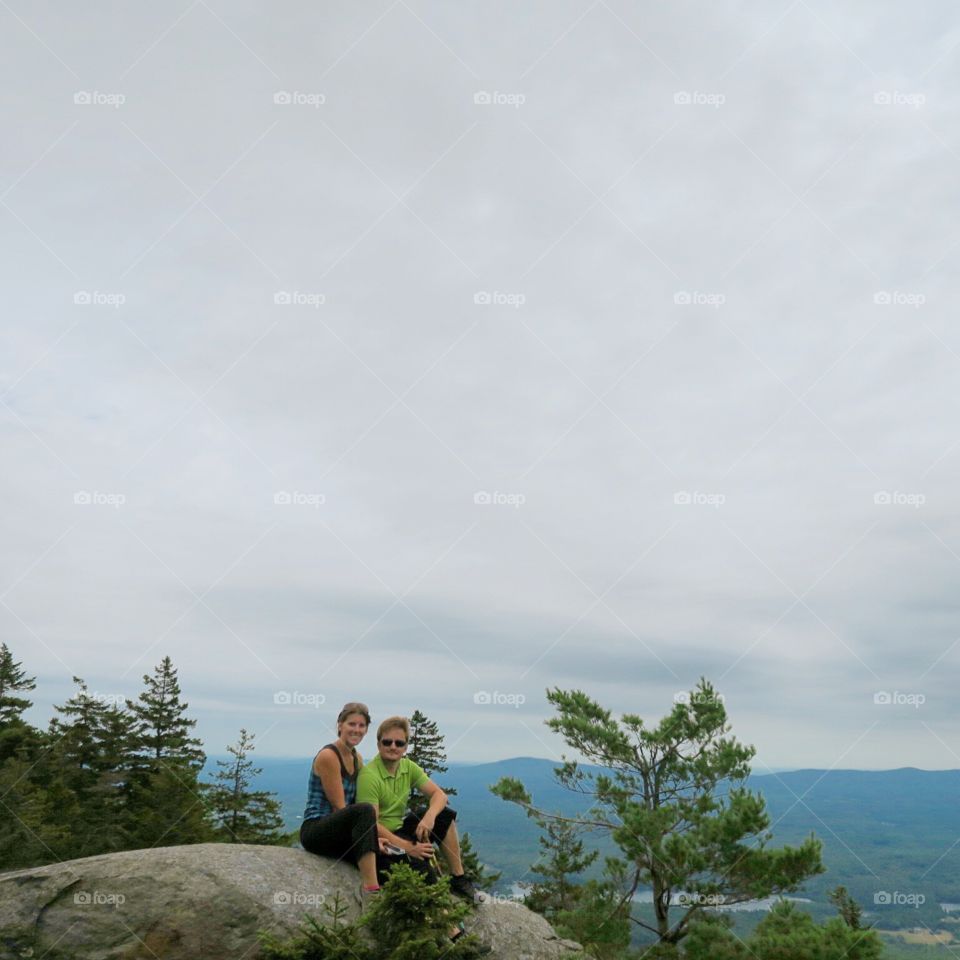 Hiking  couple  on  rocks  with cloudy  mountain  sky  behind 