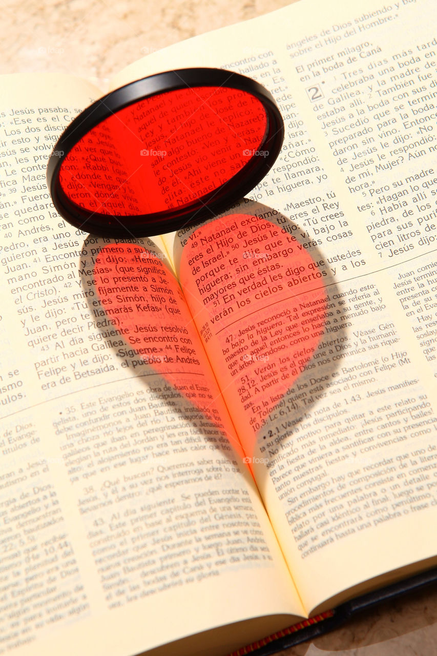 Love and reading. A heart shaped beam of light falls on a bible book