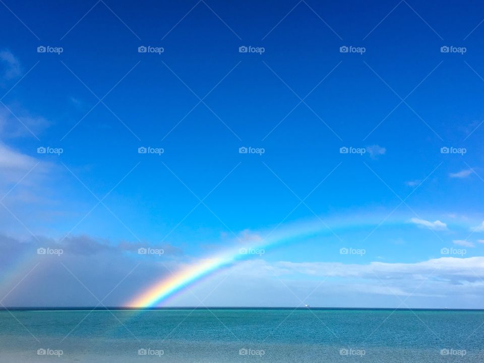 Bright colourful rainbow over the ocean