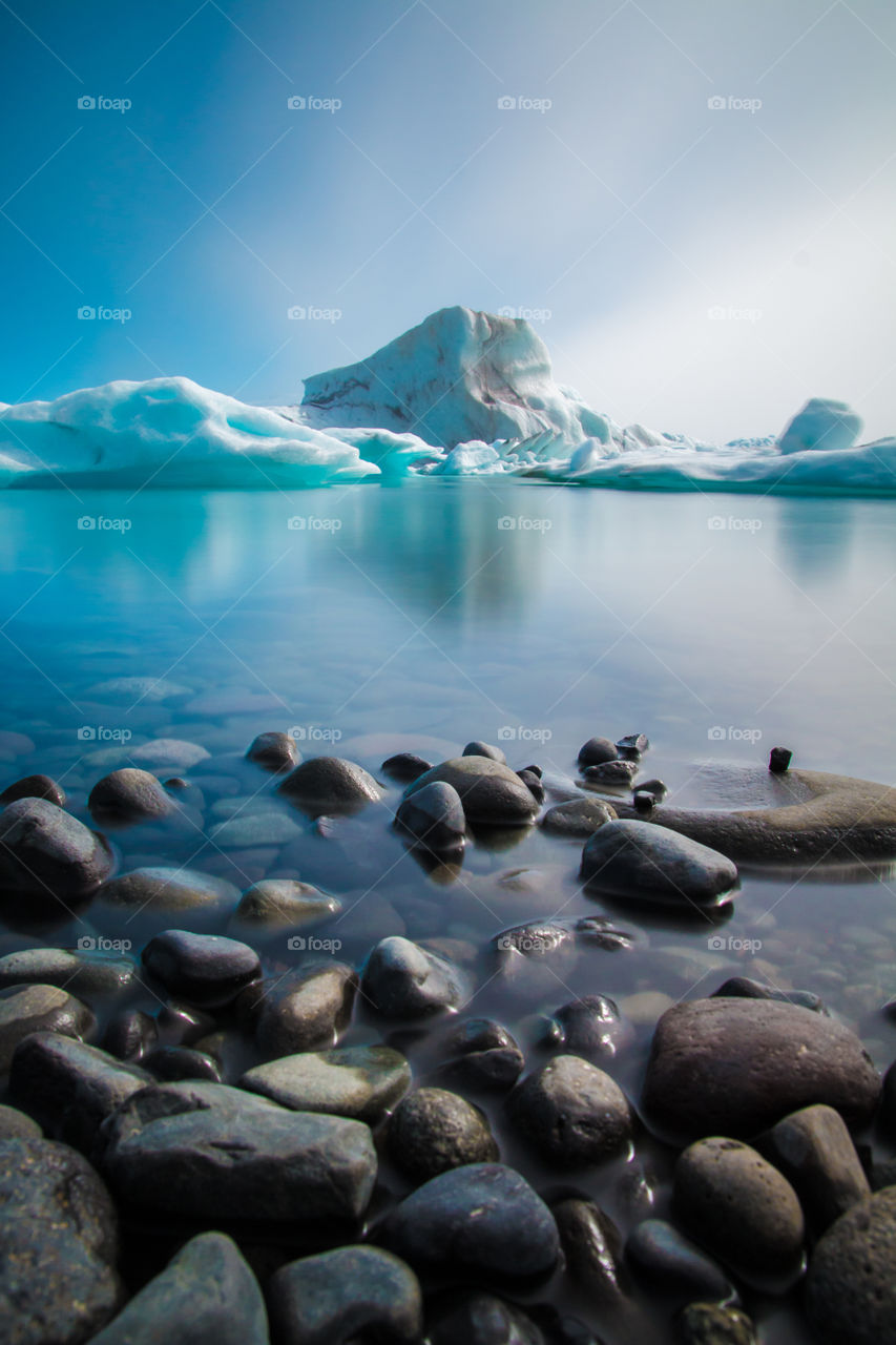 Glacier lagoon in Iceland with big pice of ice in the center of the picture with crystal clear water