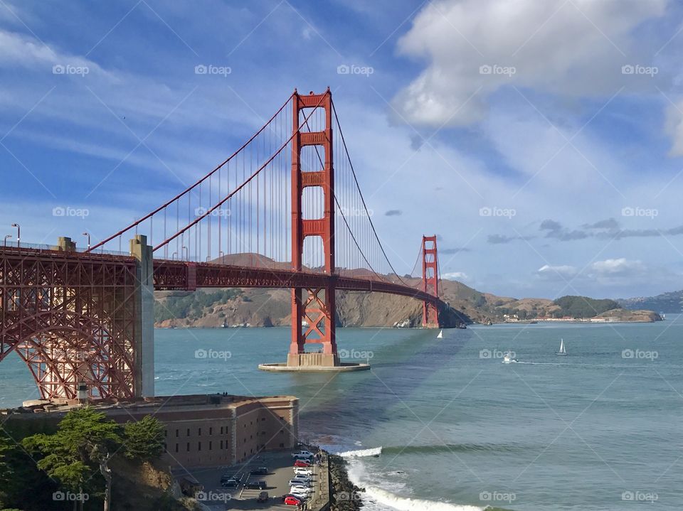 A view of the Golden Gate Bridge in the summertime with blue sky’s and clouds, choppy waters and boats - all the blues! 