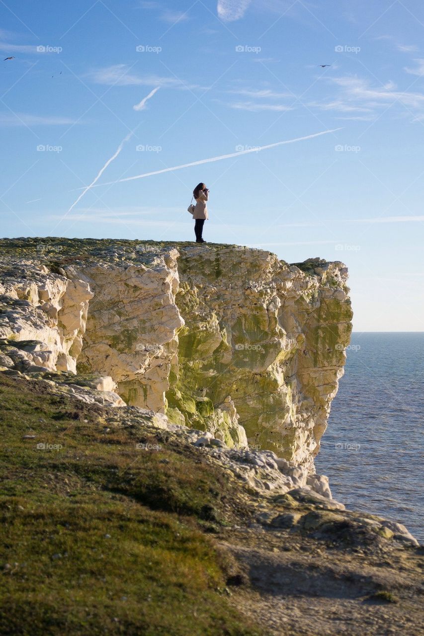 sky sea cliff side taking photos by Petalskull